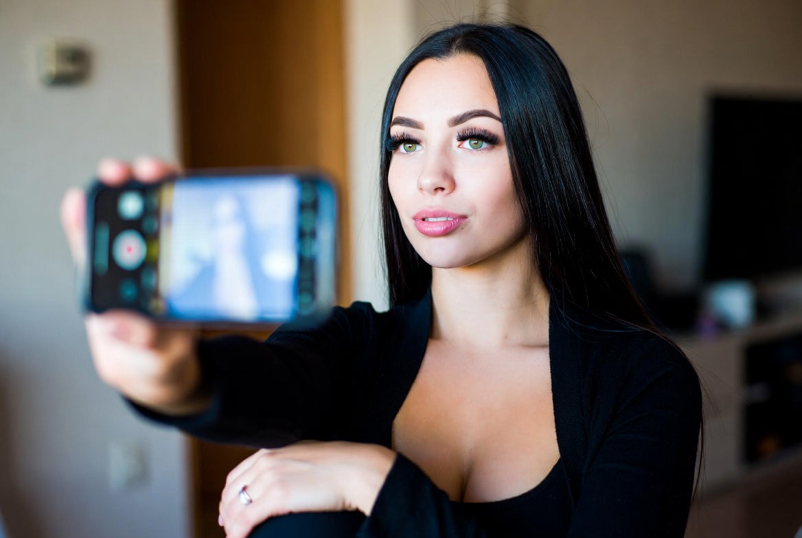Woman taking a selfie of her eyelashes