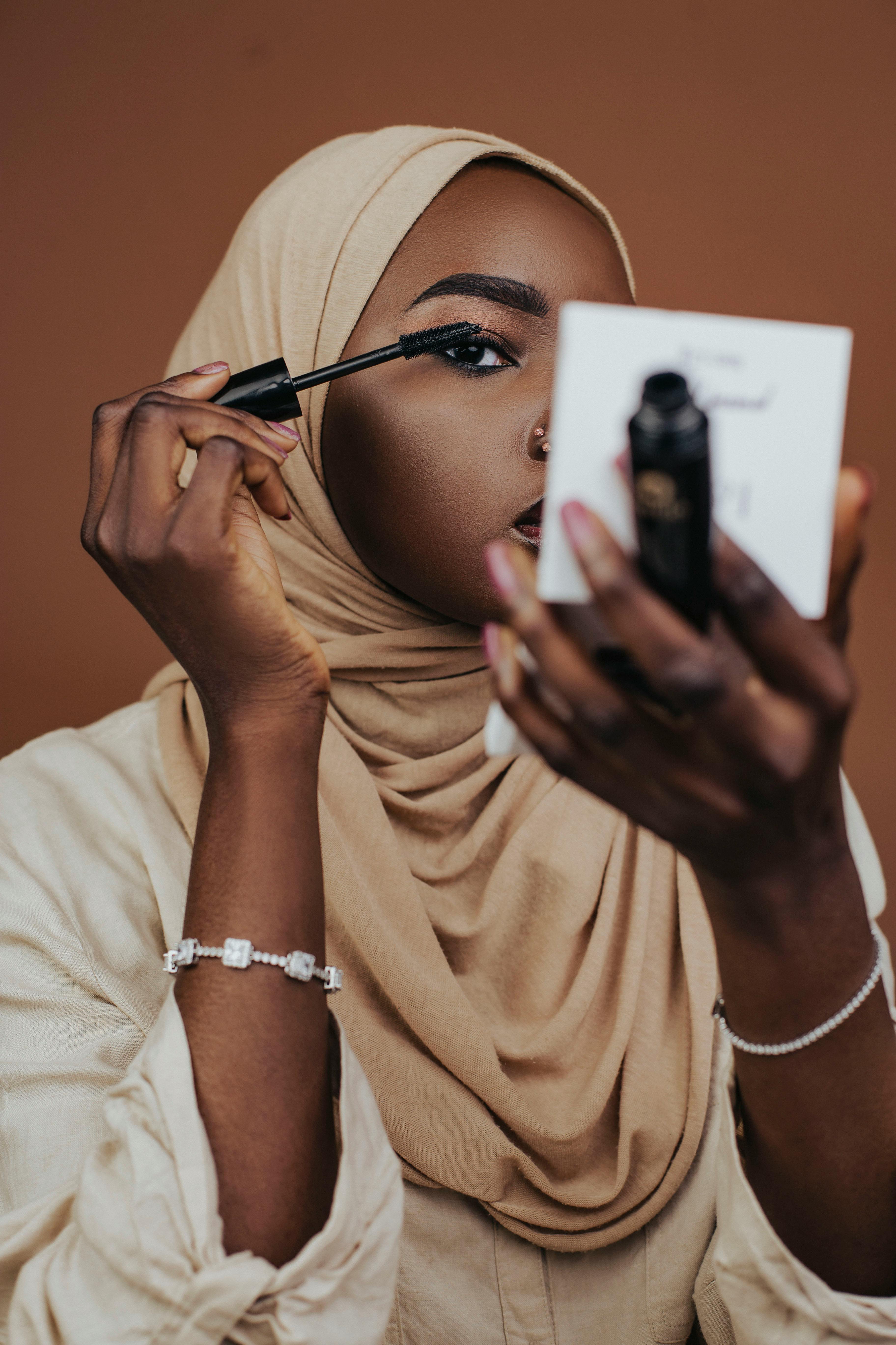 Elegant Woman Applying Makeup with Mirror